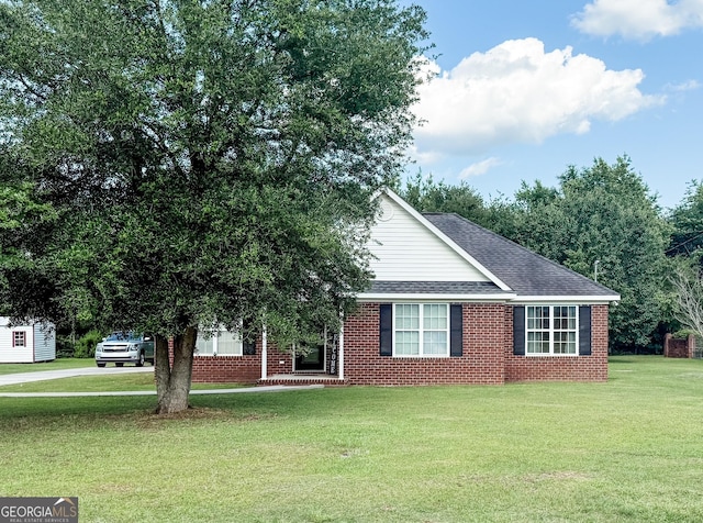 317 S Terrell St, Metter, GA 30439 - view of front of house featuring a front yard, roof with shingles, and brick siding