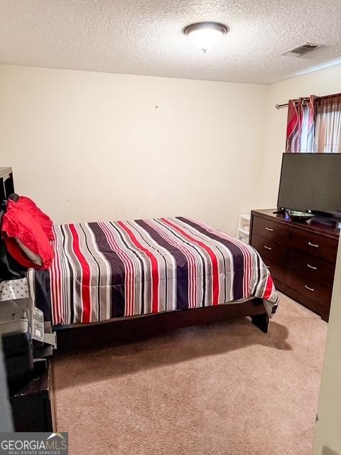 317 S Terrell St, Metter, GA 30439 - bedroom featuring carpet and a textured ceiling