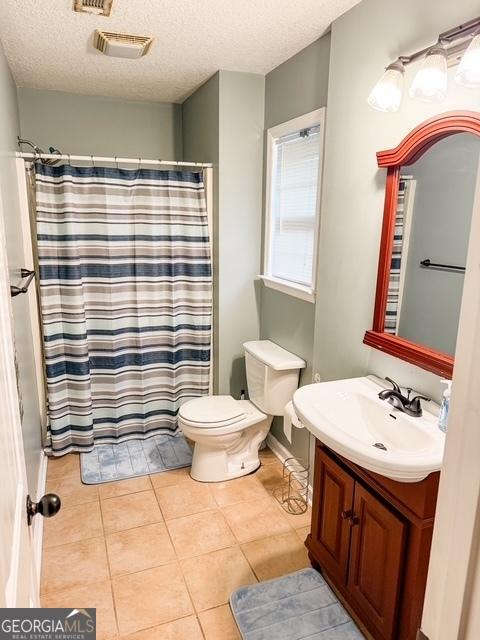 317 S Terrell St, Metter, GA 30439 - bathroom featuring toilet, vanity, tile patterned flooring, a textured ceiling, and a shower with shower curtain