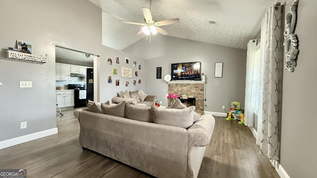 110 Waterloo Dr, Mount Airy, GA 30563 - living area featuring a ceiling fan, vaulted ceiling, wood finished floors, a fireplace, and a textured ceiling