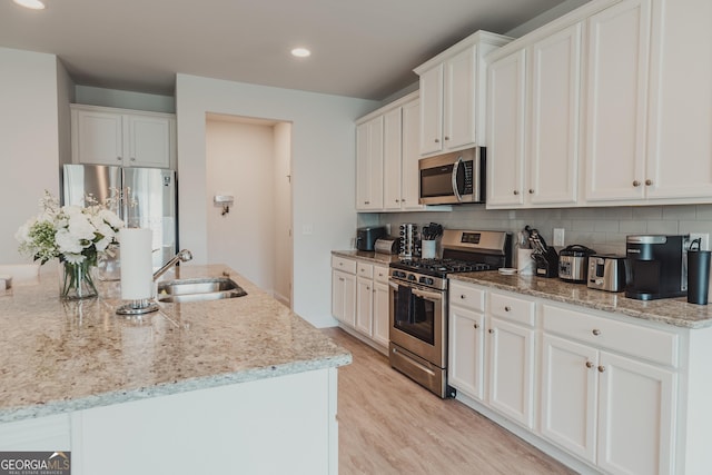 82 Castlemoor Loop, Adairsville, GA 30103 - kitchen featuring stainless steel appliances, backsplash, light wood-type flooring, white cabinetry, and recessed lighting