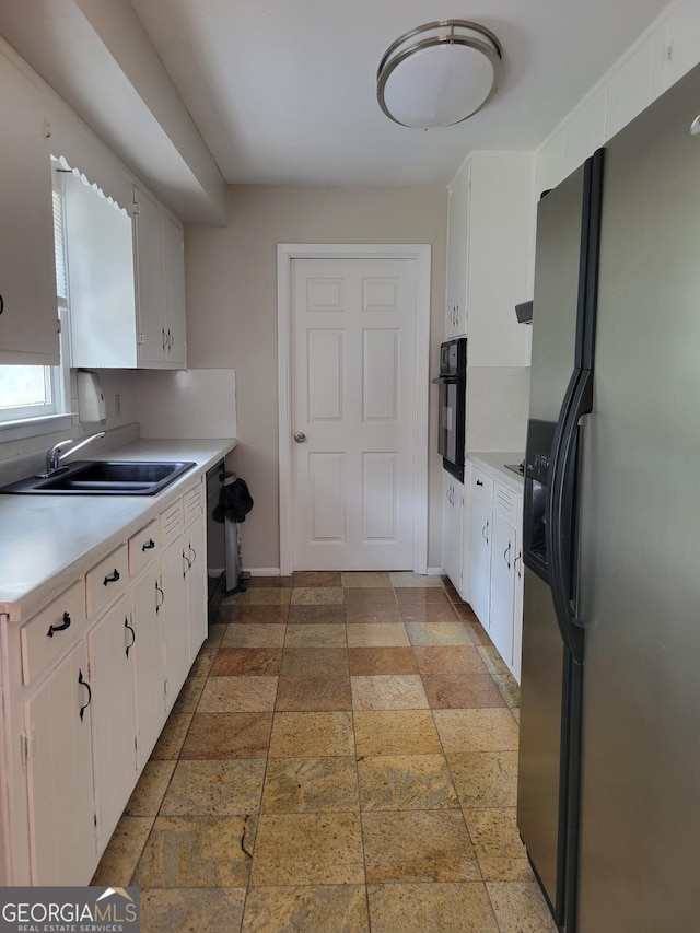 4157 Cedar Valley Ln, Conley, GA 30288 - kitchen with black appliances, a sink, light countertops, stone tile flooring, and white cabinets