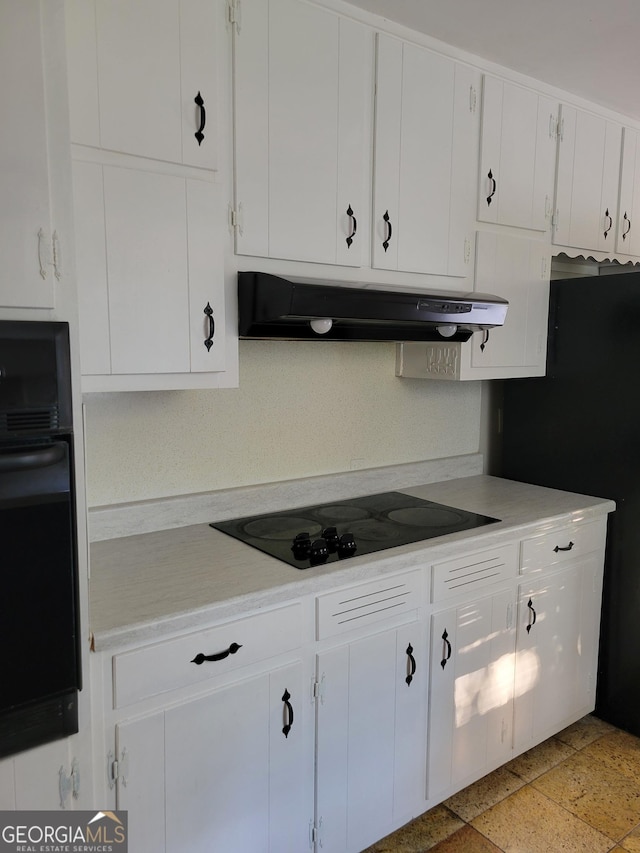 4157 Cedar Valley Ln, Conley, GA 30288 - kitchen with black appliances, ventilation hood, light countertops, and white cabinetry