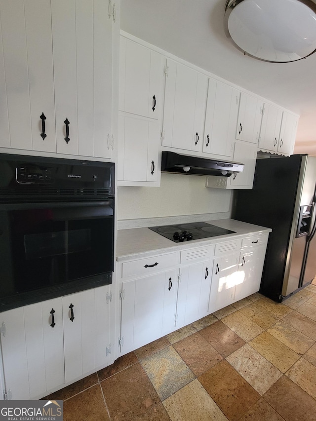 4157 Cedar Valley Ln, Conley, GA 30288 - kitchen with black appliances, under cabinet range hood, stone tile floors, and white cabinets