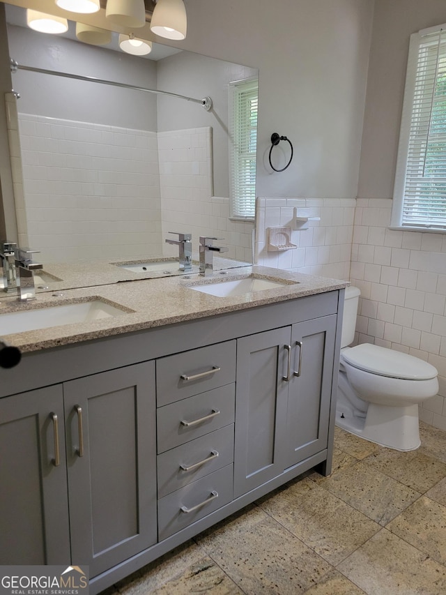 4157 Cedar Valley Ln, Conley, GA 30288 - full bath featuring tile walls, double vanity, toilet, wainscoting, and plenty of natural light
