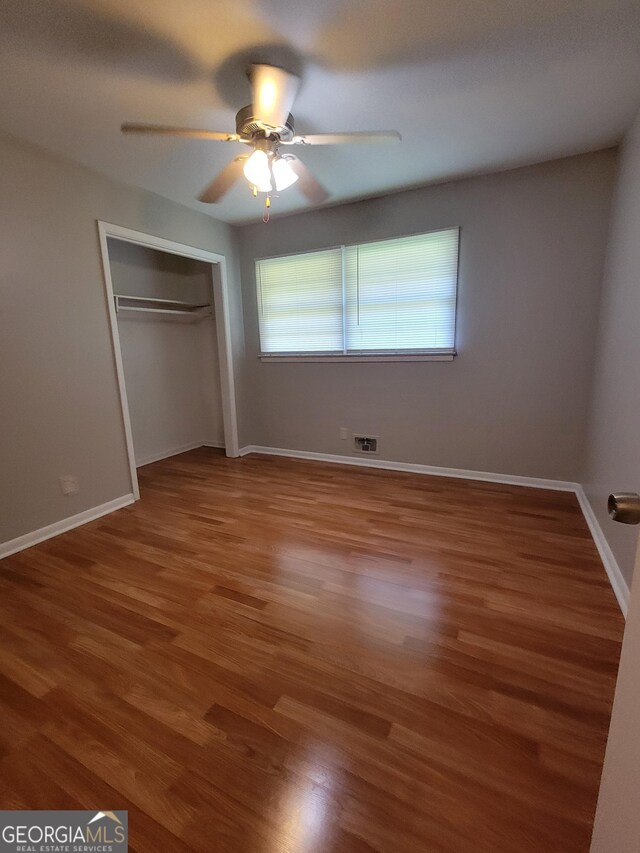 4157 Cedar Valley Ln, Conley, GA 30288 - unfurnished bedroom featuring wood finished floors, a closet, baseboards, and a ceiling fan