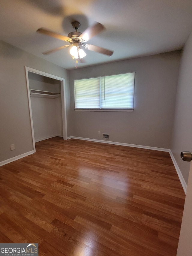 4157 Cedar Valley Ln, Conley, GA 30288 - unfurnished bedroom with wood finished floors, a closet, baseboards, and ceiling fan