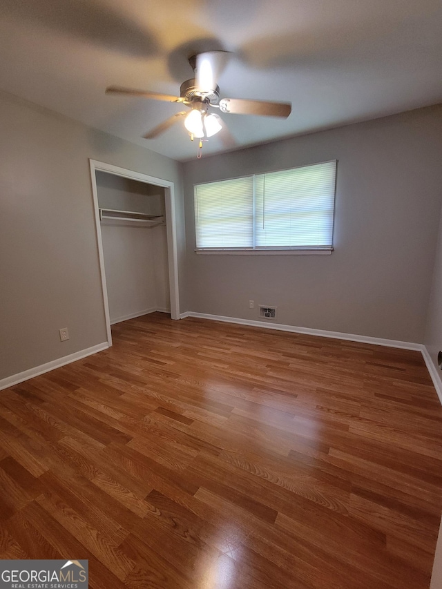 4157 Cedar Valley Ln, Conley, GA 30288 - unfurnished bedroom with wood finished floors, a closet, baseboards, and a ceiling fan