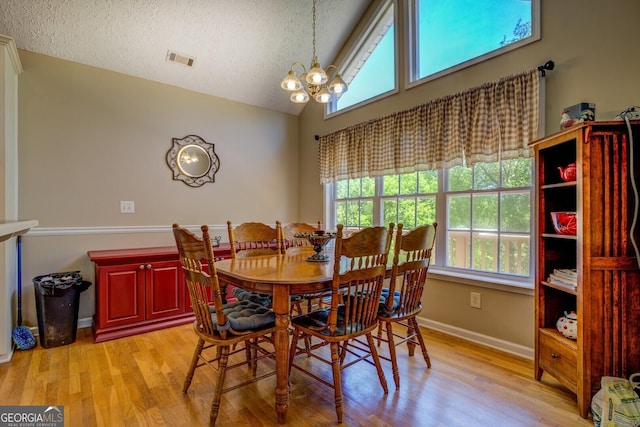 637 Lakeview Dr, Newborn, GA 30056 - dining space featuring a chandelier, light wood-type flooring, a textured ceiling, and high vaulted ceiling
