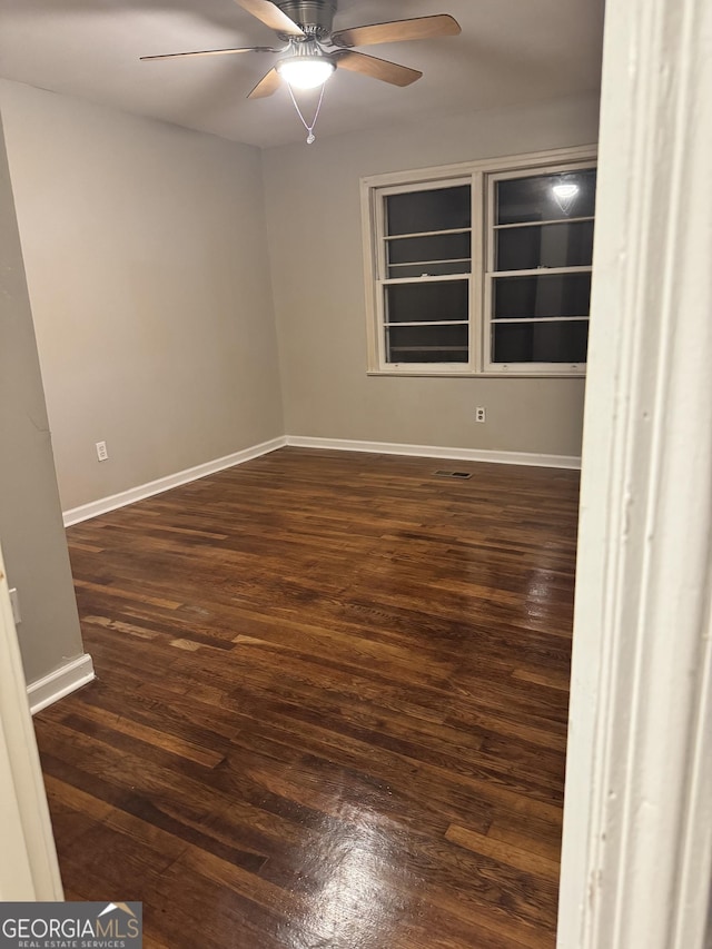 225 Bell St, Covington, GA 30016 - empty room with ceiling fan, dark wood-style floors, and baseboards