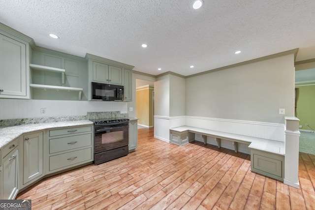 405 W Leslie Ct, Woodstock, GA 30188 - kitchen with black appliances, green cabinets, open shelves, wainscoting, and light wood-type flooring
