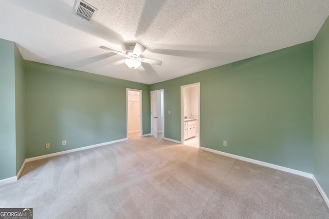 405 W Leslie Ct, Woodstock, GA 30188 - unfurnished bedroom featuring light colored carpet, a spacious closet, a textured ceiling, ensuite bathroom, and ceiling fan