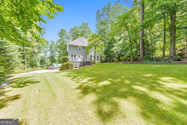 405 W Leslie Ct, Woodstock, GA 30188 - view of grassy yard featuring driveway and a deck