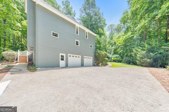405 W Leslie Ct, Woodstock, GA 30188 - view of property exterior featuring an attached garage, asphalt driveway, stairway, and view of wooded area