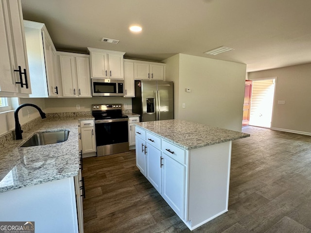 278 Stancil Dr, Toccoa, GA 30577 - kitchen with stainless steel appliances, a sink, white cabinets, dark wood-type flooring, and a kitchen island