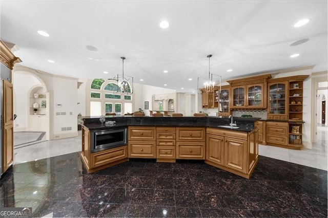9005 Old Southwick Pass, Alpharetta, GA 30022 - kitchen featuring stainless steel microwave, recessed lighting, a chandelier, glass insert cabinets, and granite floors
