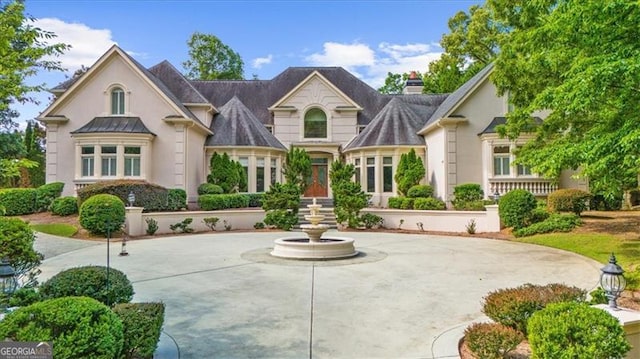 9005 Old Southwick Pass, Alpharetta, GA 30022 - view of front facade with stucco siding and a chimney