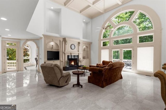 9005 Old Southwick Pass, Alpharetta, GA 30022 - living area featuring coffered ceiling, a warm lit fireplace, light marble finish floors, a towering ceiling, and french doors