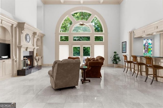 9005 Old Southwick Pass, Alpharetta, GA 30022 - living room with a towering ceiling, ceiling fan, a lit fireplace, light marble finish flooring, and french doors