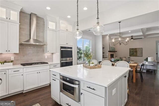 3332 Old Concord Rd SE, Smyrna, GA 30082 - kitchen with wall chimney range hood, black cooktop, dark wood-style floors, double oven, and a center island