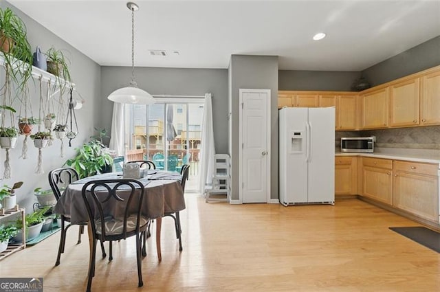 771 Tulip Poplar, Lawrenceville, GA 30044 - kitchen with white fridge with ice dispenser, stainless steel microwave, light brown cabinets, light wood finished floors, and light countertops