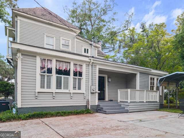 627 E Broughton St, Bainbridge, GA 39817 - view of front of property with a carport, covered porch, concrete driveway, cooling unit, and a chimney