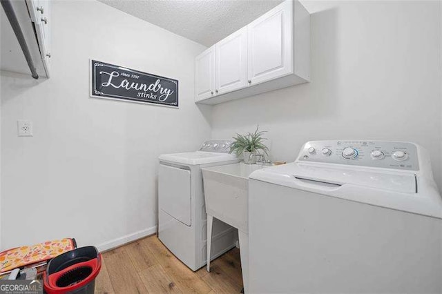 150 Kensley Way, Dallas, GA 30157 - washroom featuring independent washer and dryer, cabinet space, light wood finished floors, baseboards, and a textured ceiling