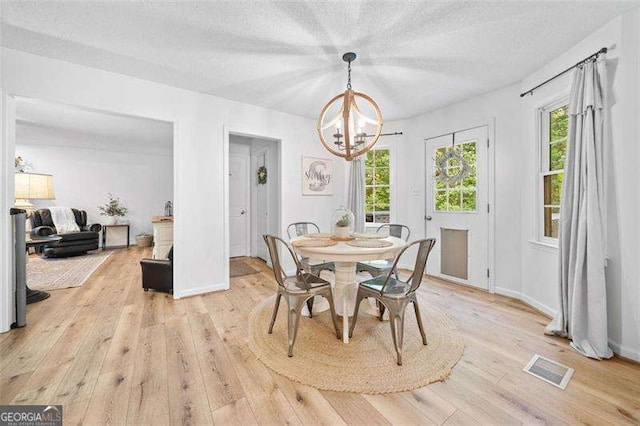 150 Kensley Way, Dallas, GA 30157 - dining area featuring a chandelier, light wood-style floors, plenty of natural light, and a textured ceiling