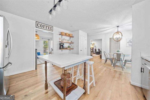 150 Kensley Way, Dallas, GA 30157 - kitchen featuring stainless steel fridge with ice dispenser, a textured ceiling, light wood-style flooring, pendant lighting, and open shelves