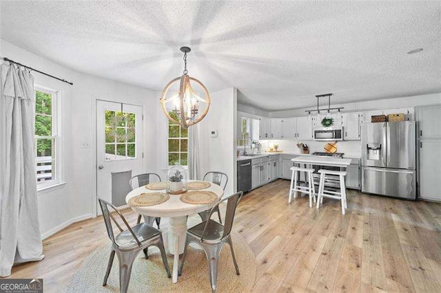 150 Kensley Way, Dallas, GA 30157 - dining area featuring a chandelier, light wood-style floors, and a textured ceiling