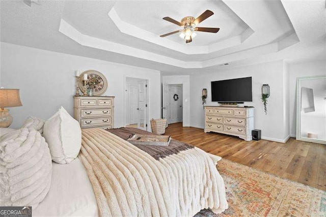 150 Kensley Way, Dallas, GA 30157 - bedroom featuring a tray ceiling, wood finished floors, baseboards, and a ceiling fan