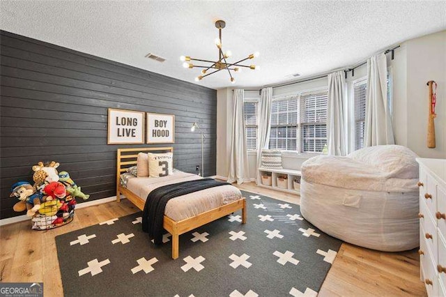 150 Kensley Way, Dallas, GA 30157 - bedroom with a chandelier, wood finished floors, a textured ceiling, and baseboards