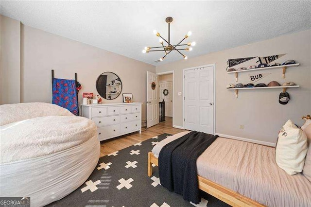 150 Kensley Way, Dallas, GA 30157 - bedroom featuring a chandelier, light wood-type flooring, and baseboards