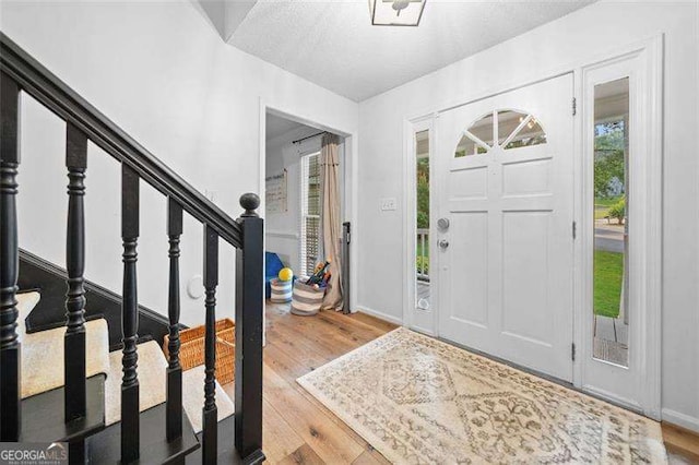 150 Kensley Way, Dallas, GA 30157 - foyer entrance with healthy amount of natural light, wood finished floors, stairs, and baseboards