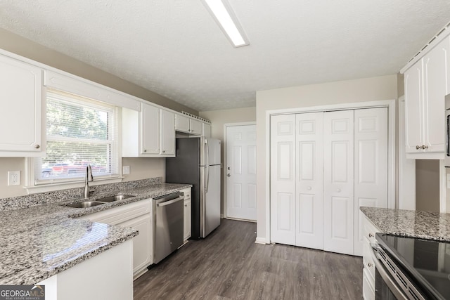 11102 Hunters Ln, Hampton, GA 30228 - kitchen with stainless steel appliances, a sink, white cabinetry, dark wood finished floors, and a textured ceiling