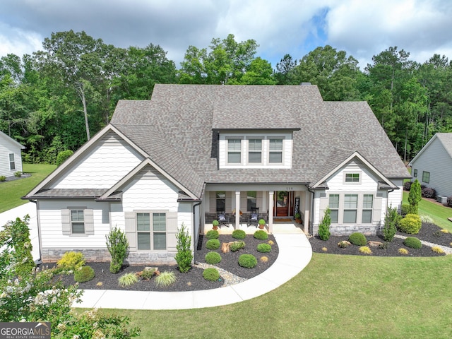 119 Waterview Cir, Newnan, GA 30263 - craftsman house featuring stone siding, roof with shingles, a front lawn, and covered porch