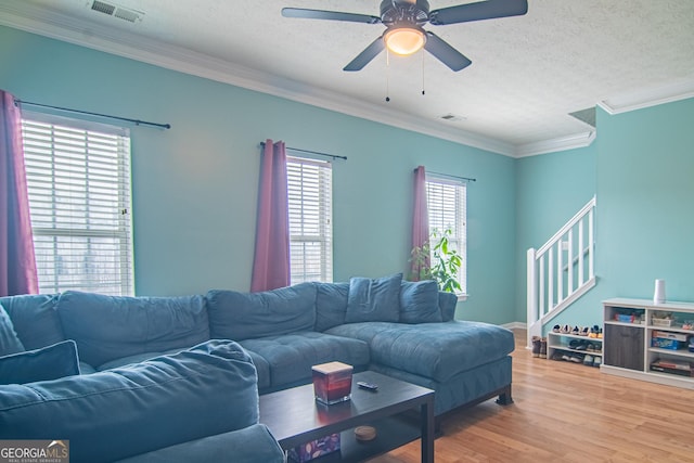 4336 Thorngate Ln, Acworth, GA 30101 - living area featuring ornamental molding, wood finished floors, ceiling fan, stairs, and a textured ceiling