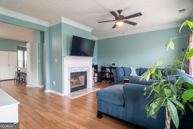4336 Thorngate Ln, Acworth, GA 30101 - living room with ceiling fan, light wood finished floors, a premium fireplace, and ornamental molding