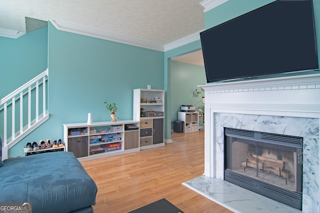 4336 Thorngate Ln, Acworth, GA 30101 - living room with ornamental molding, a premium fireplace, wood finished floors, stairs, and a textured ceiling