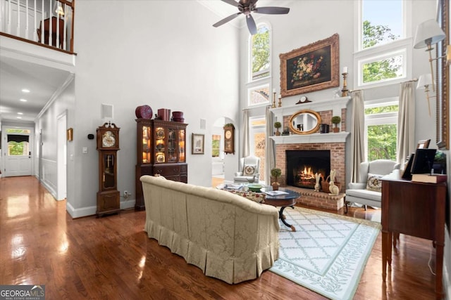 771 Rattlesnake Rdg, Dawsonville, GA 30534 - living room featuring a towering ceiling, a brick fireplace, a ceiling fan, wood finished floors, and plenty of natural light
