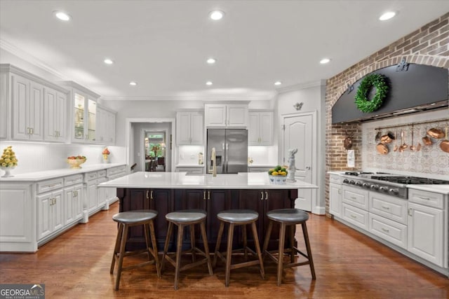 771 Rattlesnake Rdg, Dawsonville, GA 30534 - kitchen with appliances with stainless steel finishes, extractor fan, crown molding, a breakfast bar area, and light countertops