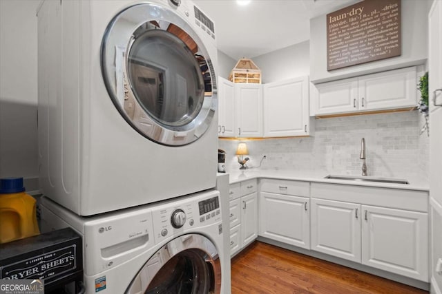 771 Rattlesnake Rdg, Dawsonville, GA 30534 - laundry room with stacked washing machine and dryer, wood finished floors, and cabinet space