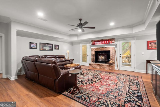 771 Rattlesnake Rdg, Dawsonville, GA 30534 - living room featuring light wood-style floors, ornamental molding, ceiling fan, a raised ceiling, and a wood stove