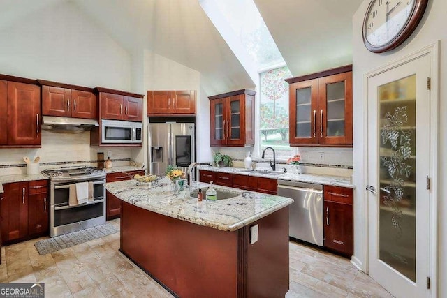 3493 Wood Acres Blvd, Duluth, GA 30096 - kitchen with stainless steel appliances, backsplash, under cabinet range hood, light stone countertops, and a kitchen island with sink