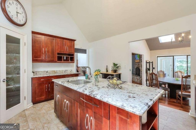 3493 Wood Acres Blvd, Duluth, GA 30096 - kitchen featuring open shelves, light stone counters, a chandelier, a kitchen island with sink, and high vaulted ceiling