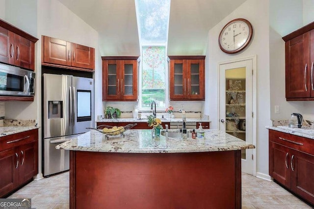 3493 Wood Acres Blvd, Duluth, GA 30096 - kitchen with stainless steel appliances, light stone counters, glass insert cabinets, a sink, and lofted ceiling