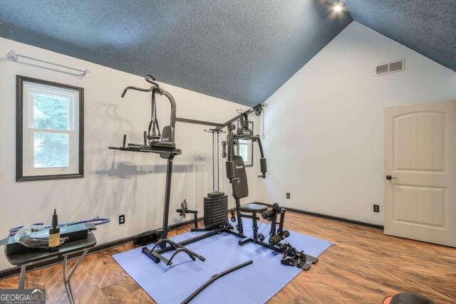 3493 Wood Acres Blvd, Duluth, GA 30096 - workout room featuring a textured ceiling, lofted ceiling, and baseboards
