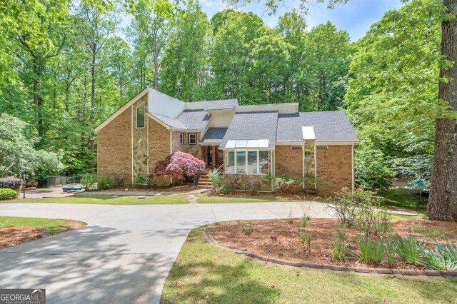 3493 Wood Acres Blvd, Duluth, GA 30096 - mid-century home with curved driveway, brick siding, and a shingled roof