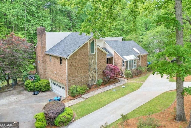 3493 Wood Acres Blvd, Duluth, GA 30096 - view of front of home with concrete driveway, a chimney, an attached garage, and brick siding