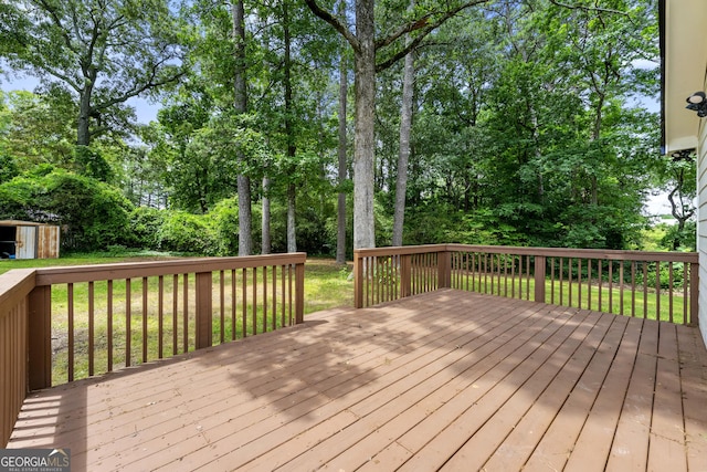 381 Warner St SE, Marietta, GA 30060 - deck with a storage unit, view of wooded area, and a yard